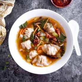 vegetable wonton soup in a white bowl