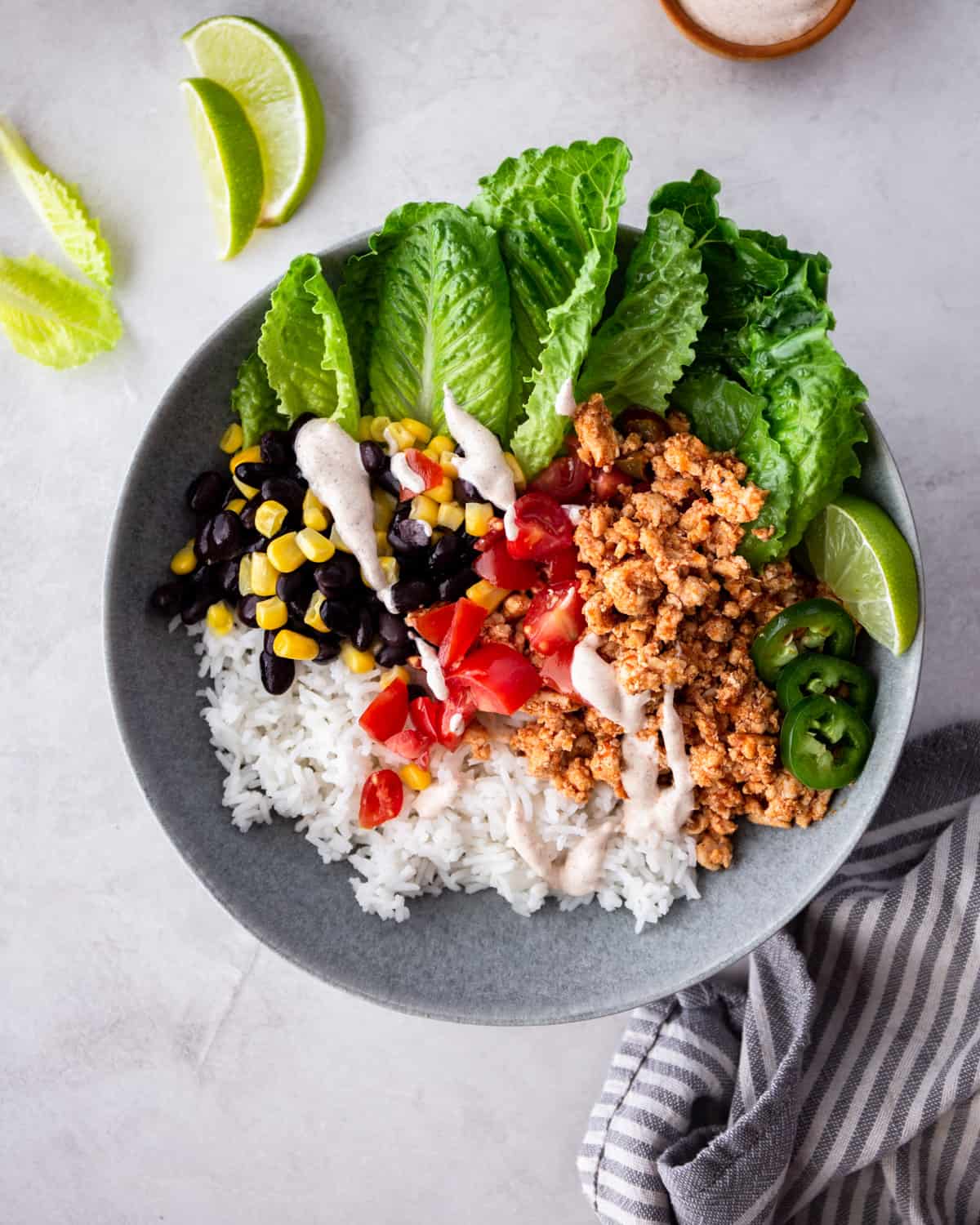 chicken and rice in a grey bowl with beans and lettuce