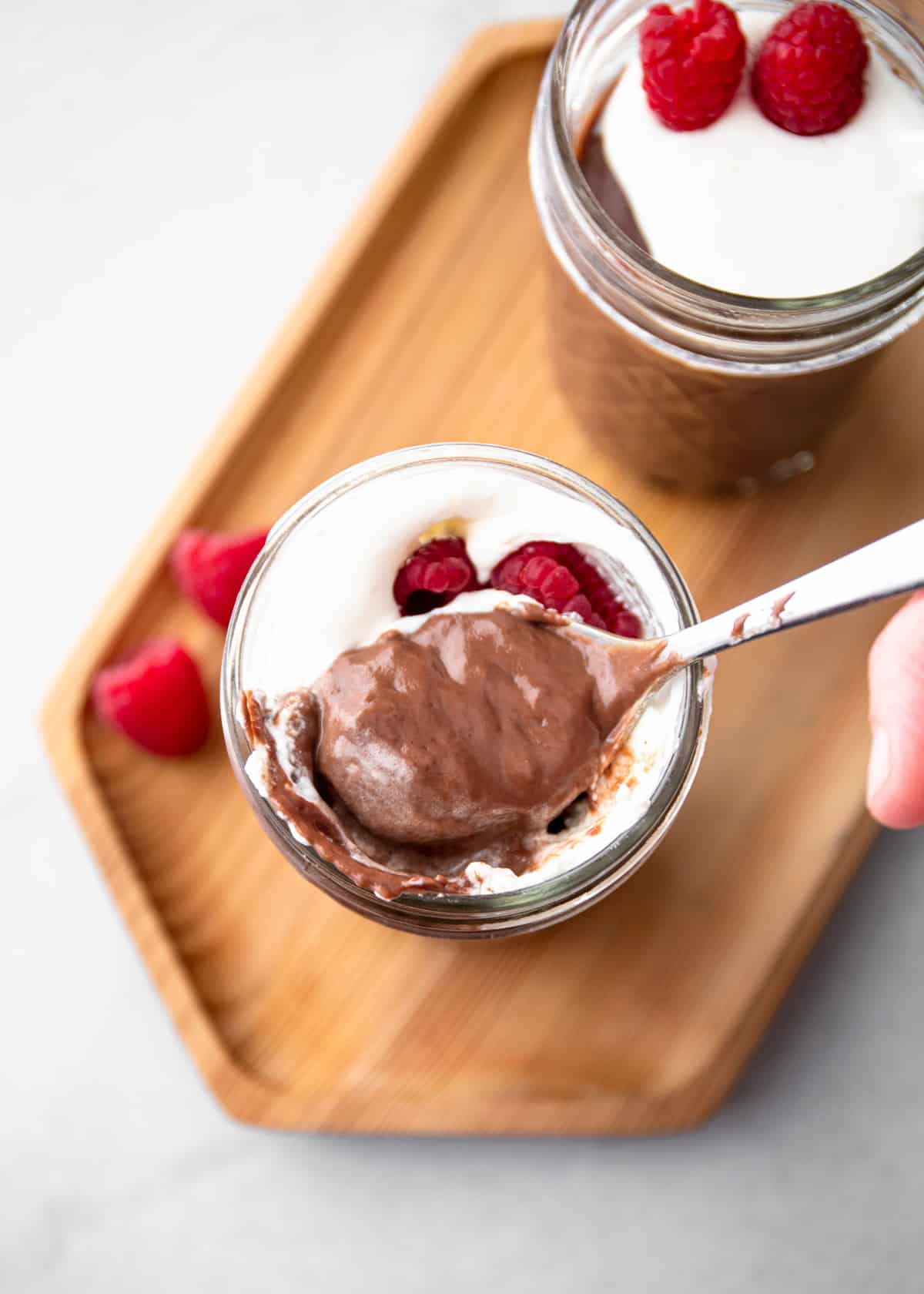 a spoonful of chocolate pudding over a glass jar full of pudding
