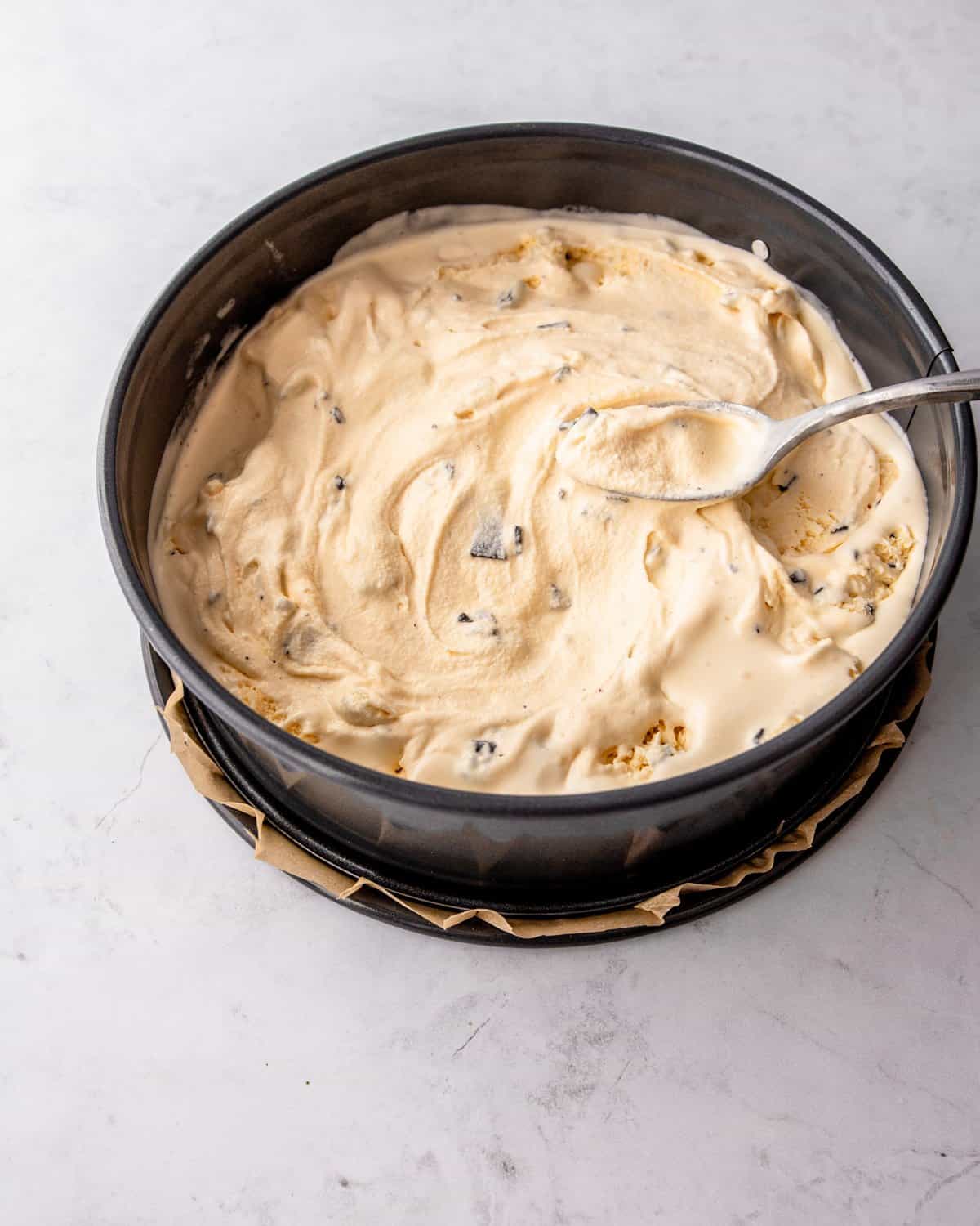 adding ice cream layer to cake in a springform pan