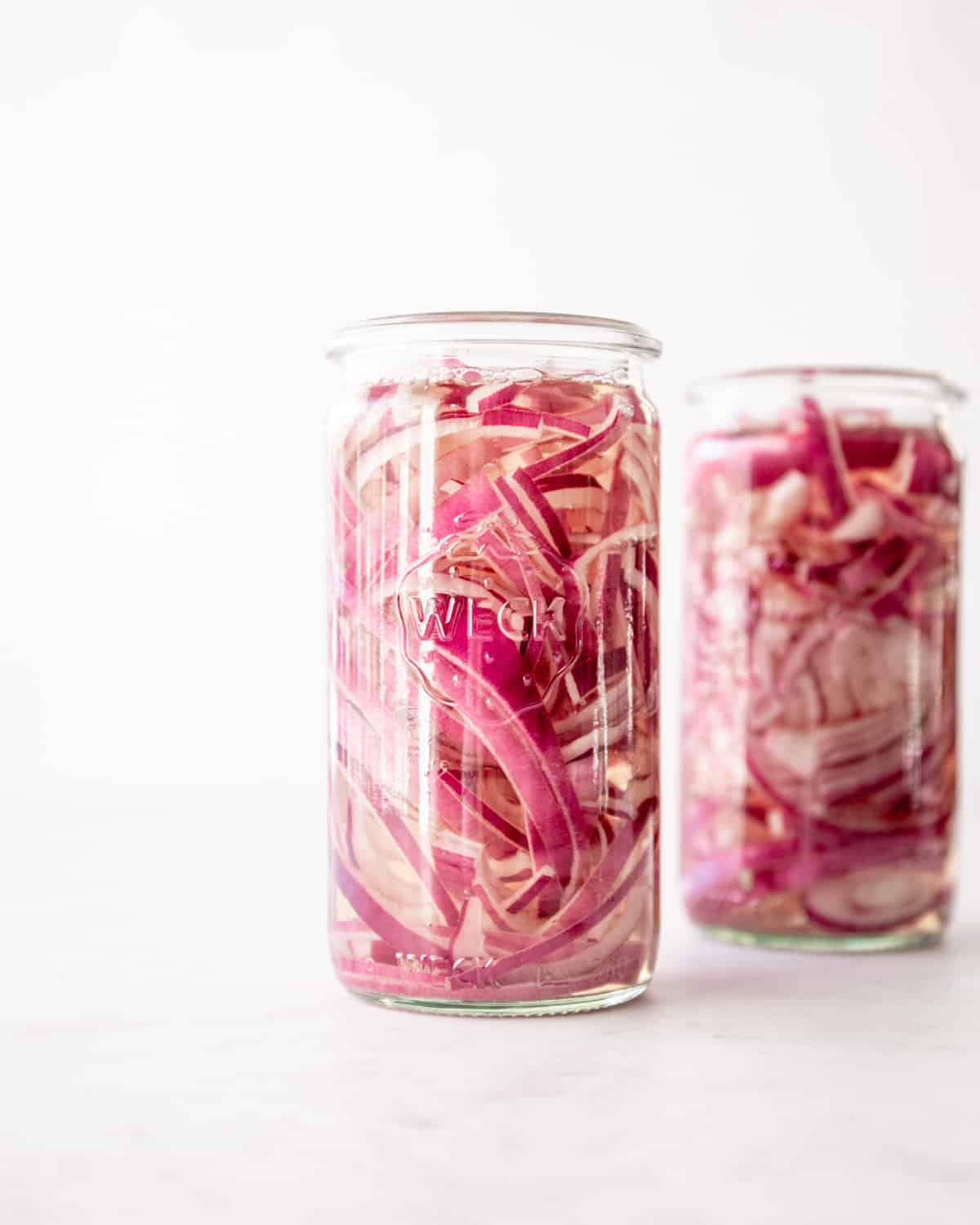 red onions pickling in glass jars