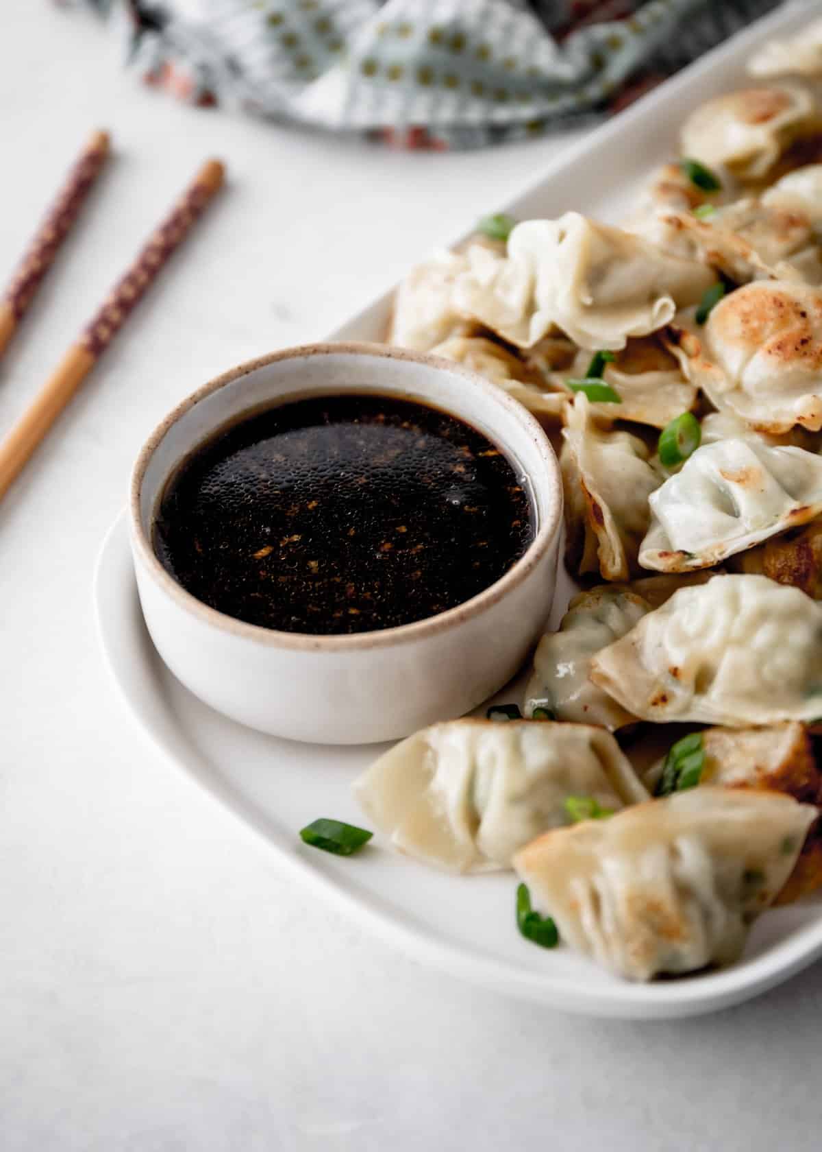 dumplings and sauce on a white platter