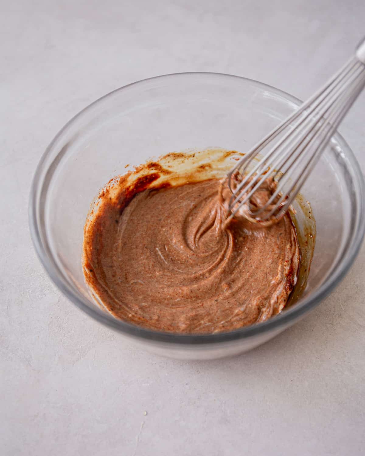 overhead image of stirring sauce in a small glass bowl