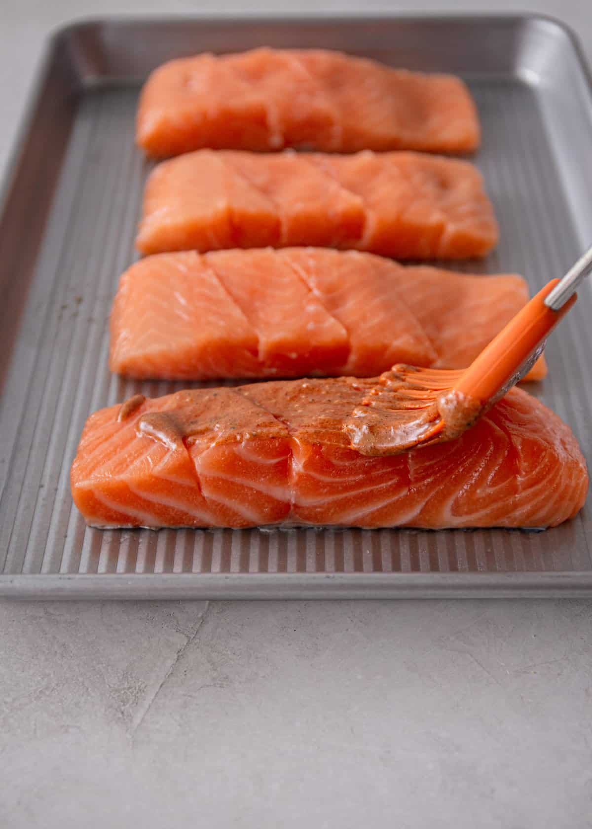 brushing salmon fillets with marinade