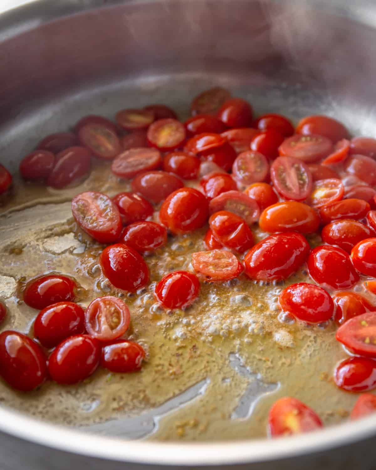 sauteeing cherry tomatoes in a skillet