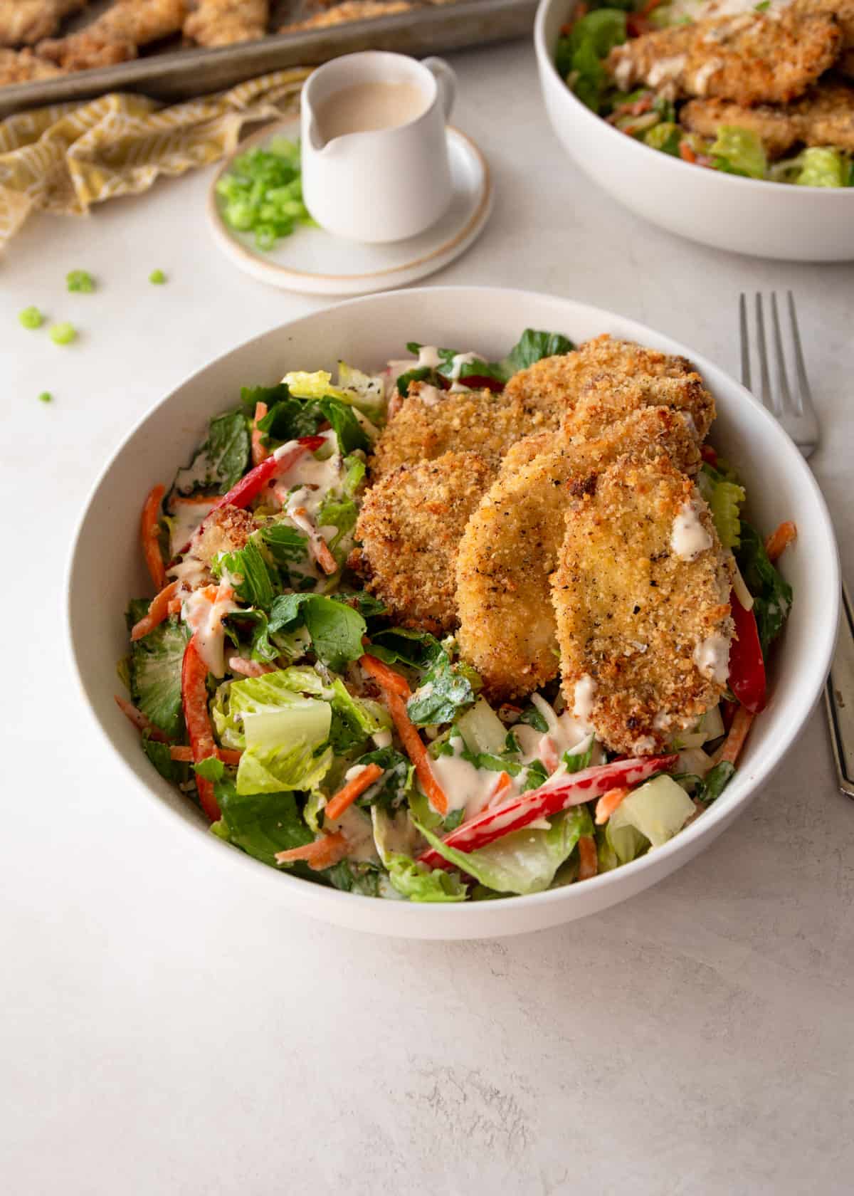 salad with chicken tenders in a white bowl