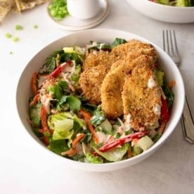 crispy chicken on a salad in a white bowl