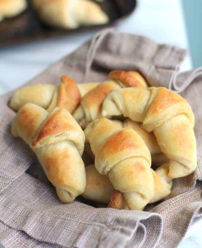 crescent rolls in a basket lined with a brown towel