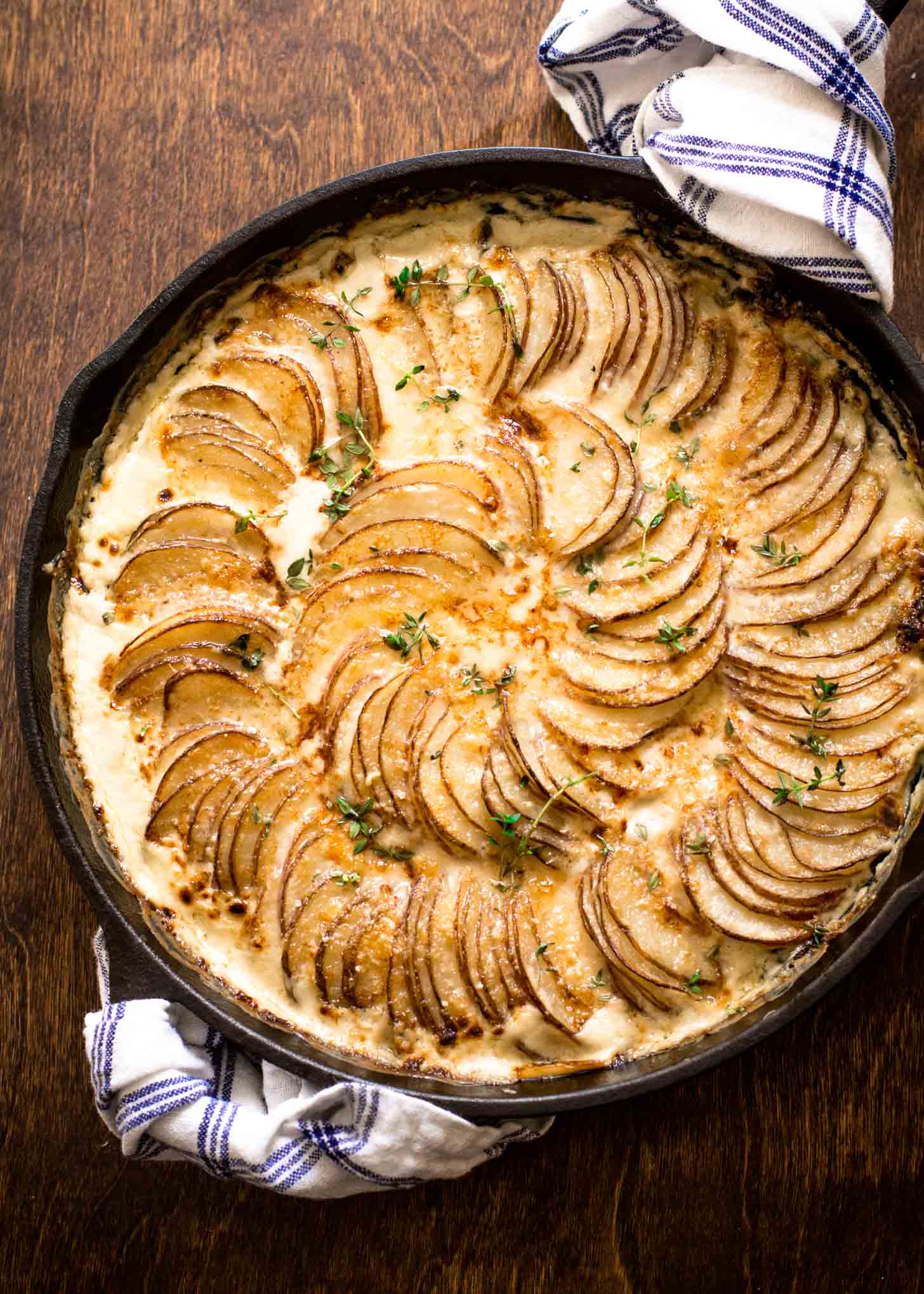 overhead view of au gratin potatoes in a spiral in a cast iron skillet