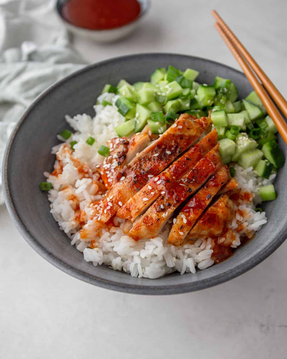 sliced chicken, chopped cucumbers and rice in a grey cowl