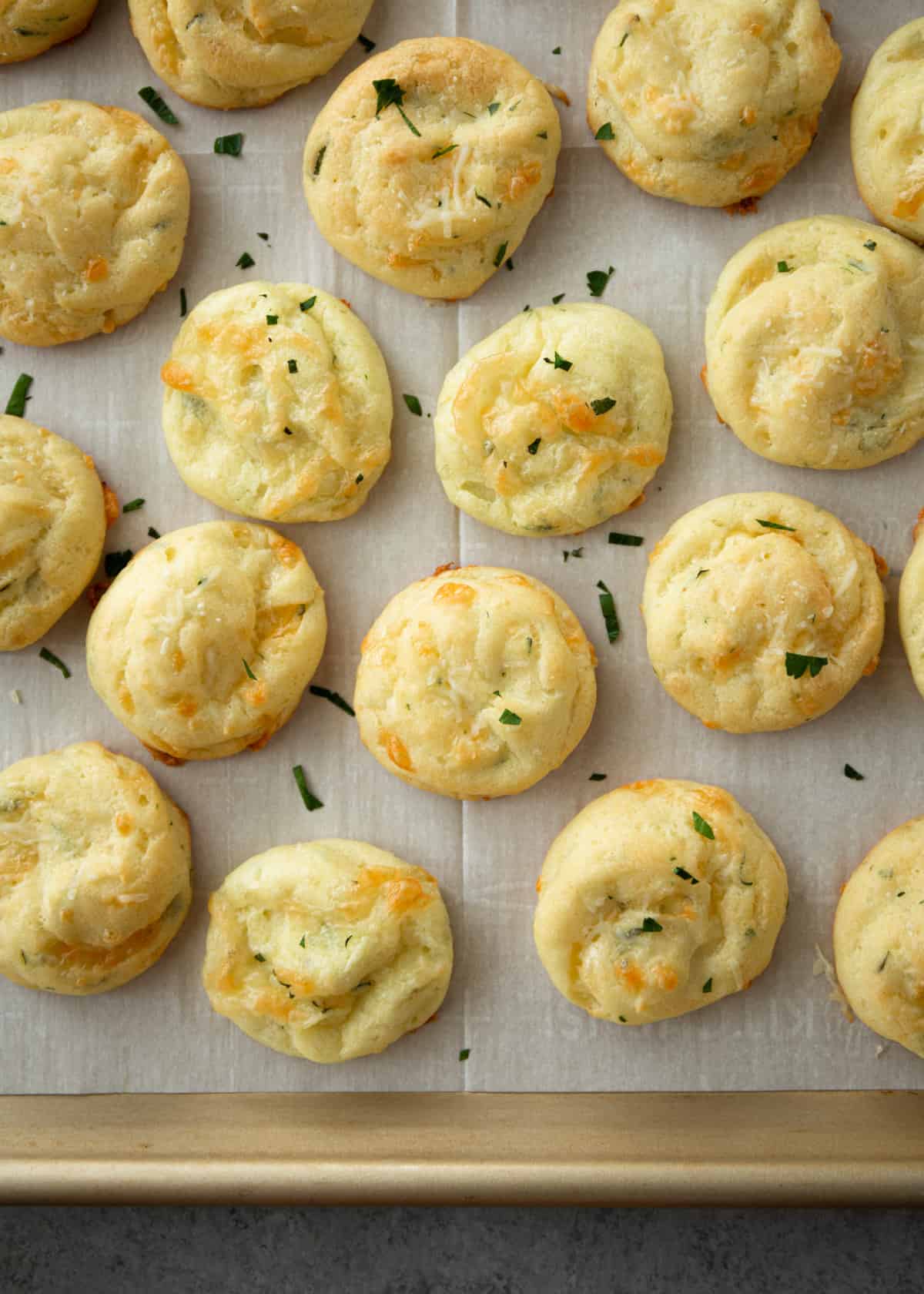 cheese puffs on a parchment lined sheet pan