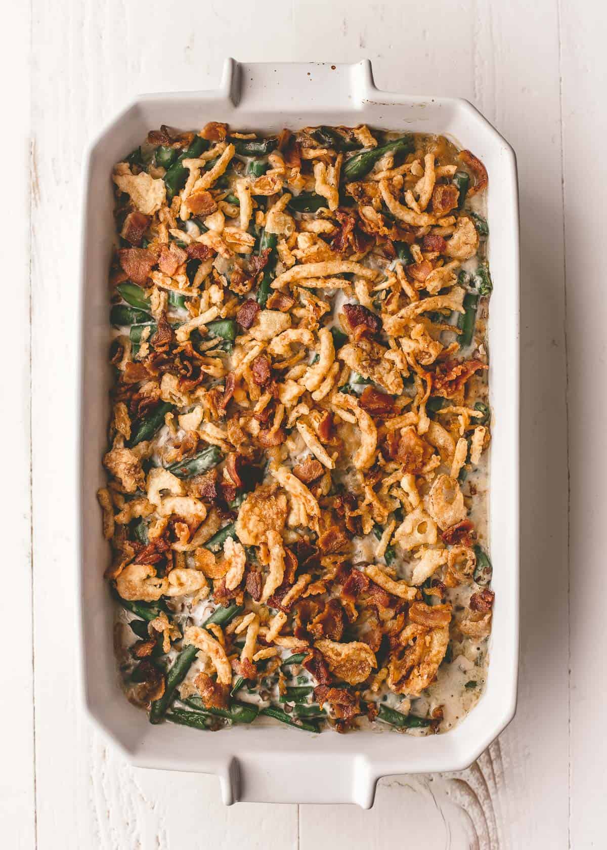 overhead view of green bean casserole in a rectangular white baking dish on a white table