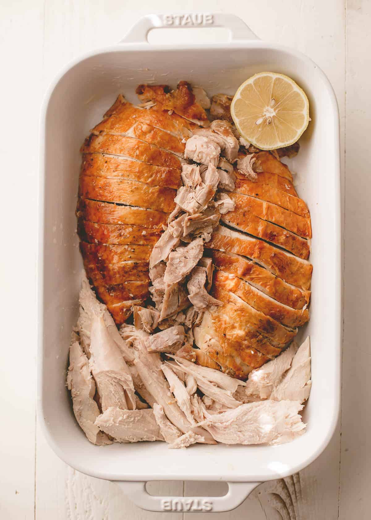 a sliced turkey in a white rectangular baking dish
