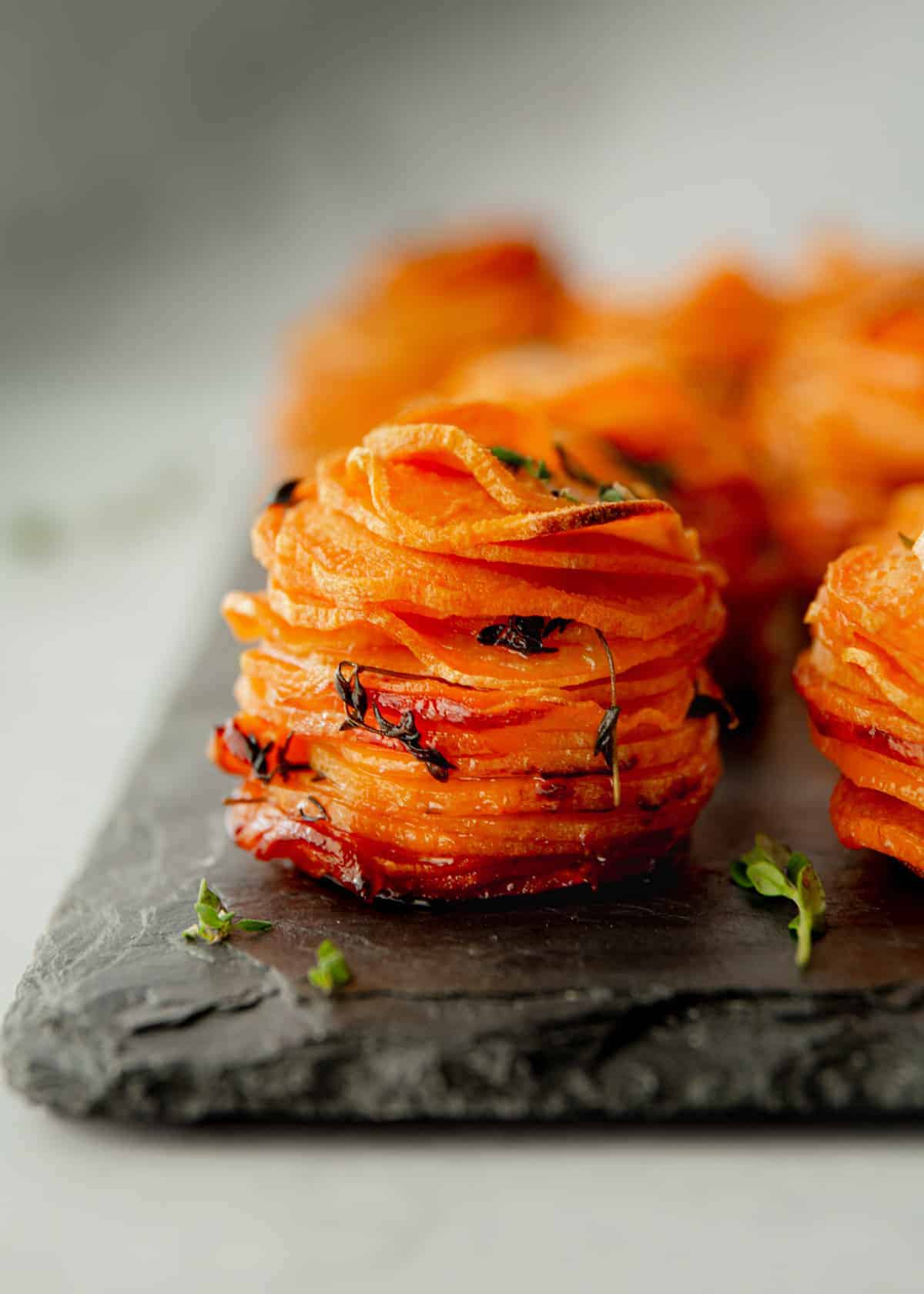 stacks of sliced sweet potatoes on a grey board