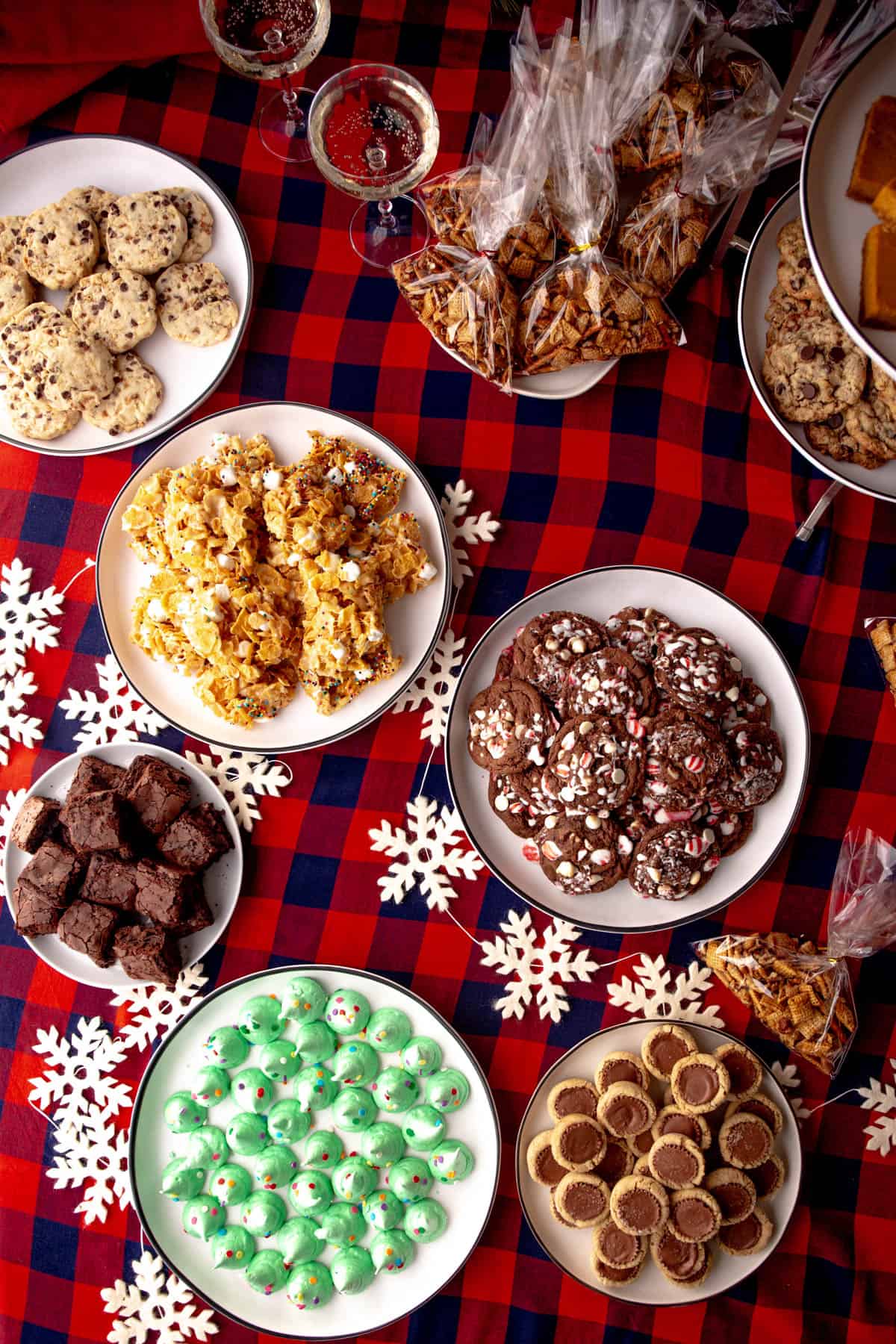 plates of Christmas cookies on a red and navy plaid tablecloth