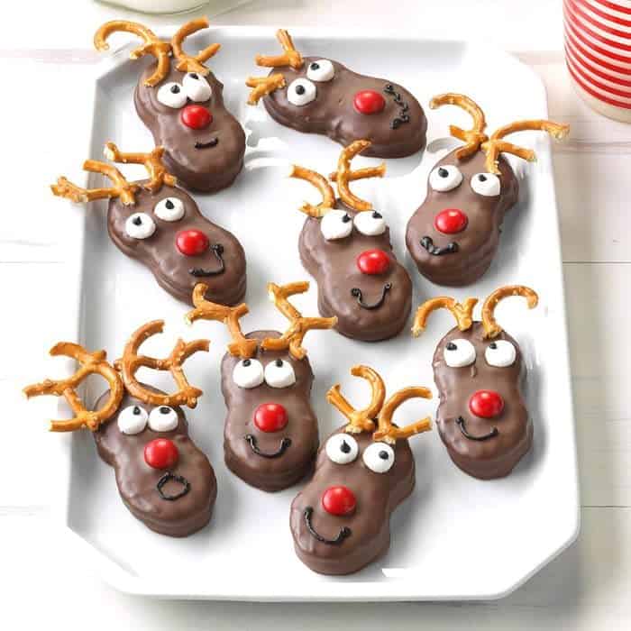 reindeer cookies with pretzel antlers on a white tray