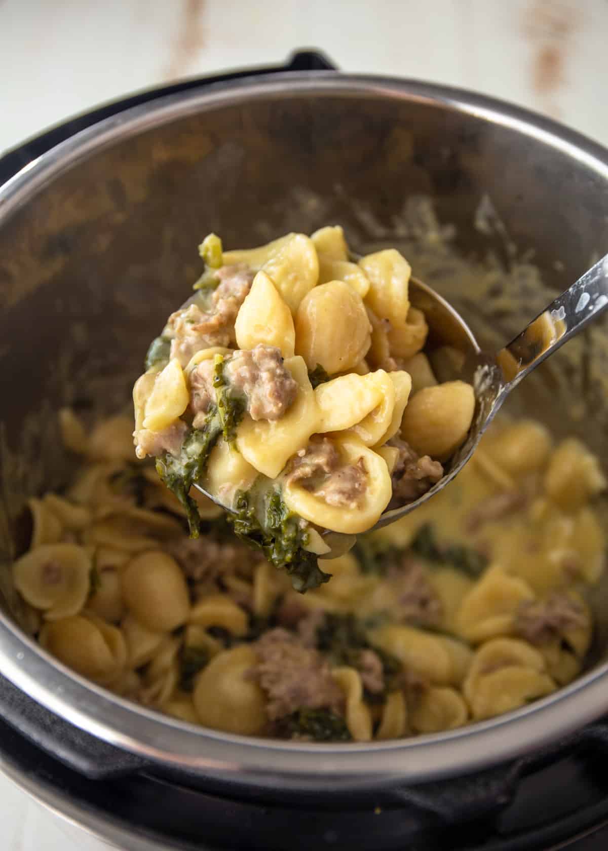 a spoonful of sausage pasta over an instant pot