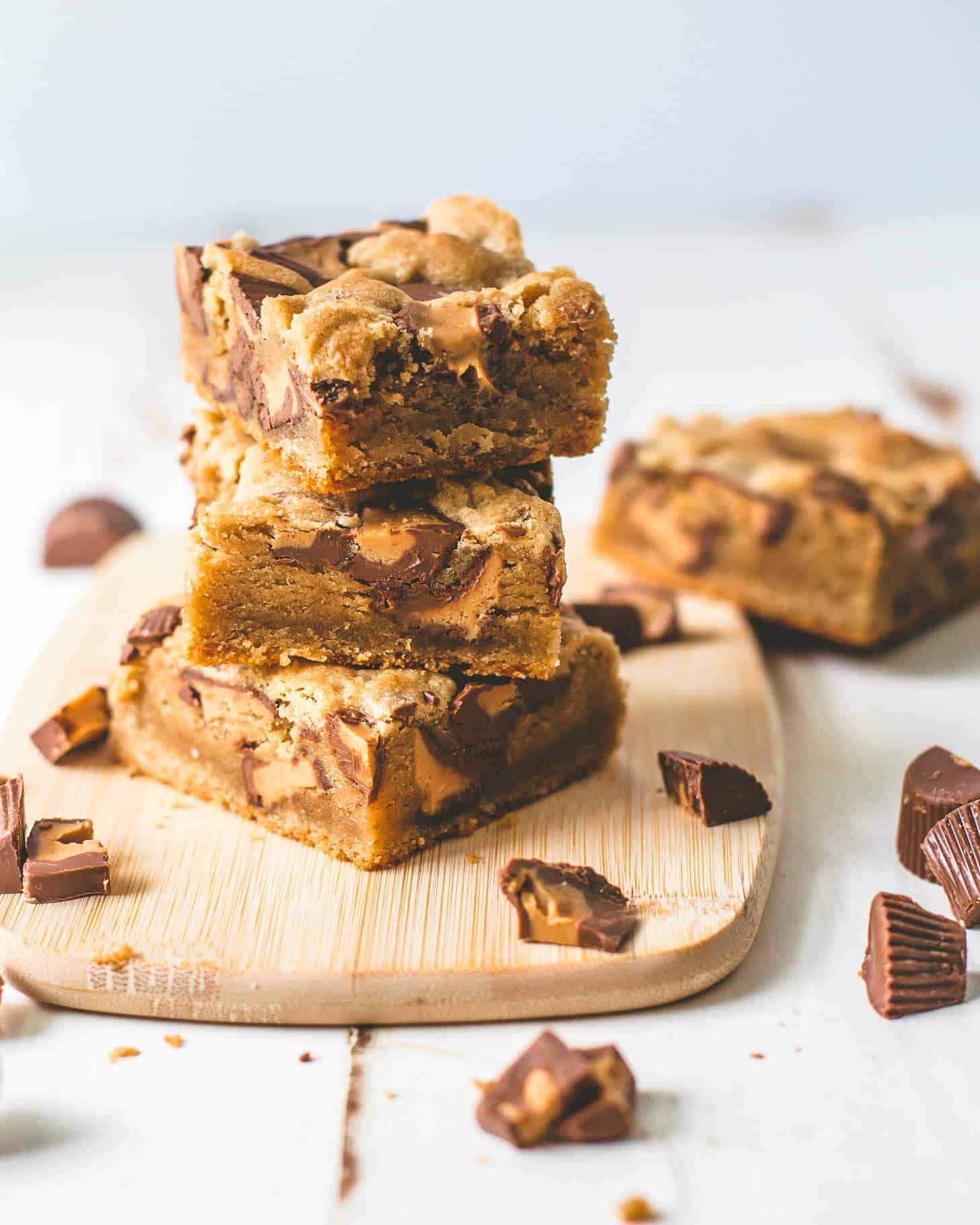 peanut butter brownies stacked on a wooden cutting board