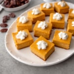 pumpkin cheesecake bars on a white platter