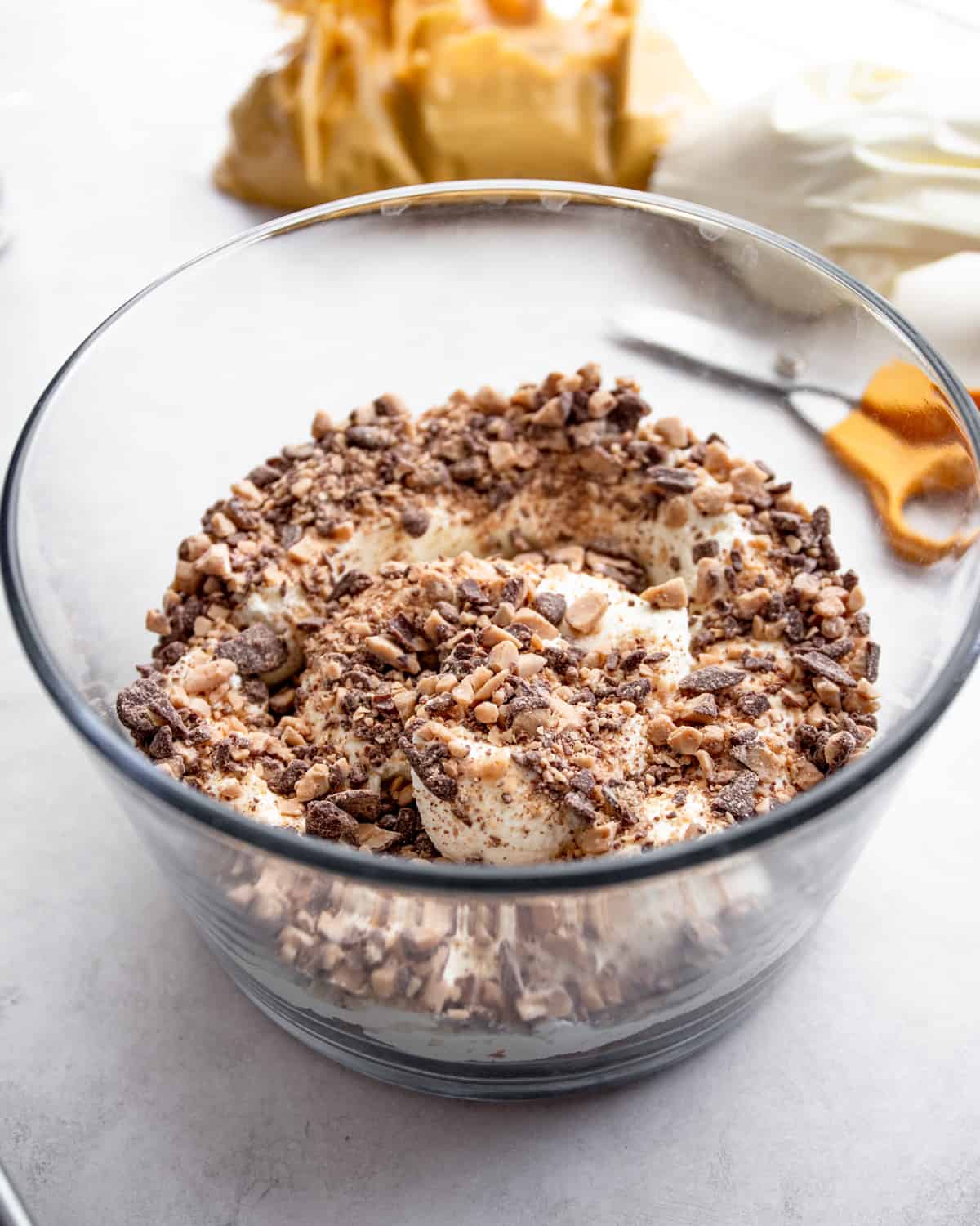 mixing trifle ingredients in a trifle bowl