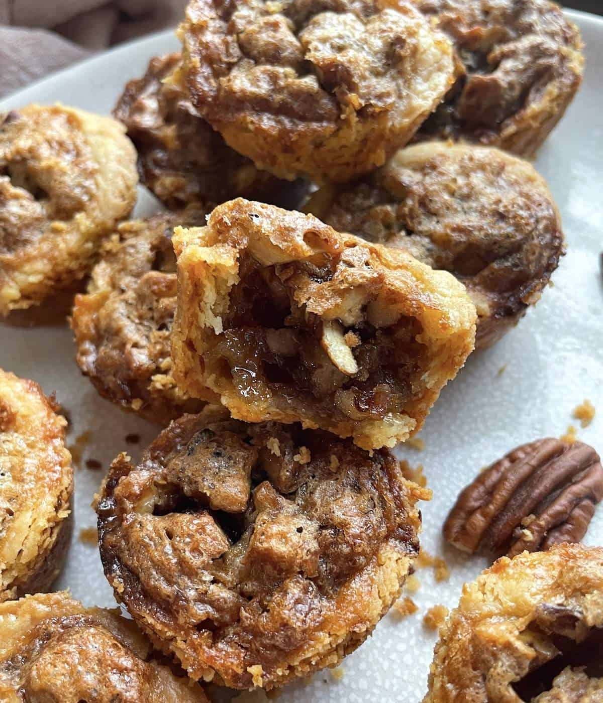 pecan tarts stacked on a white plate