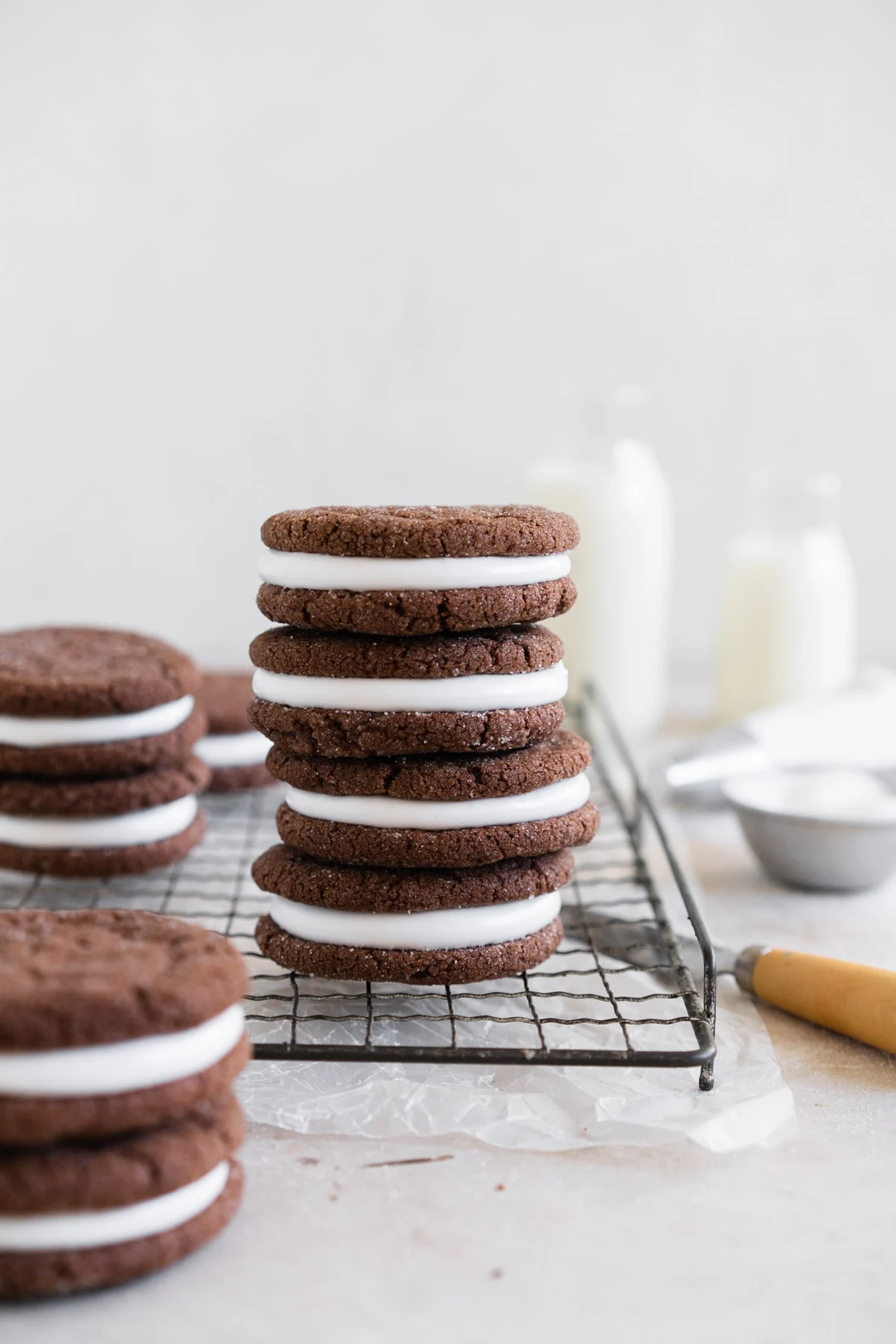 chocolate sandwich cookies stacked on a wire cooling rack