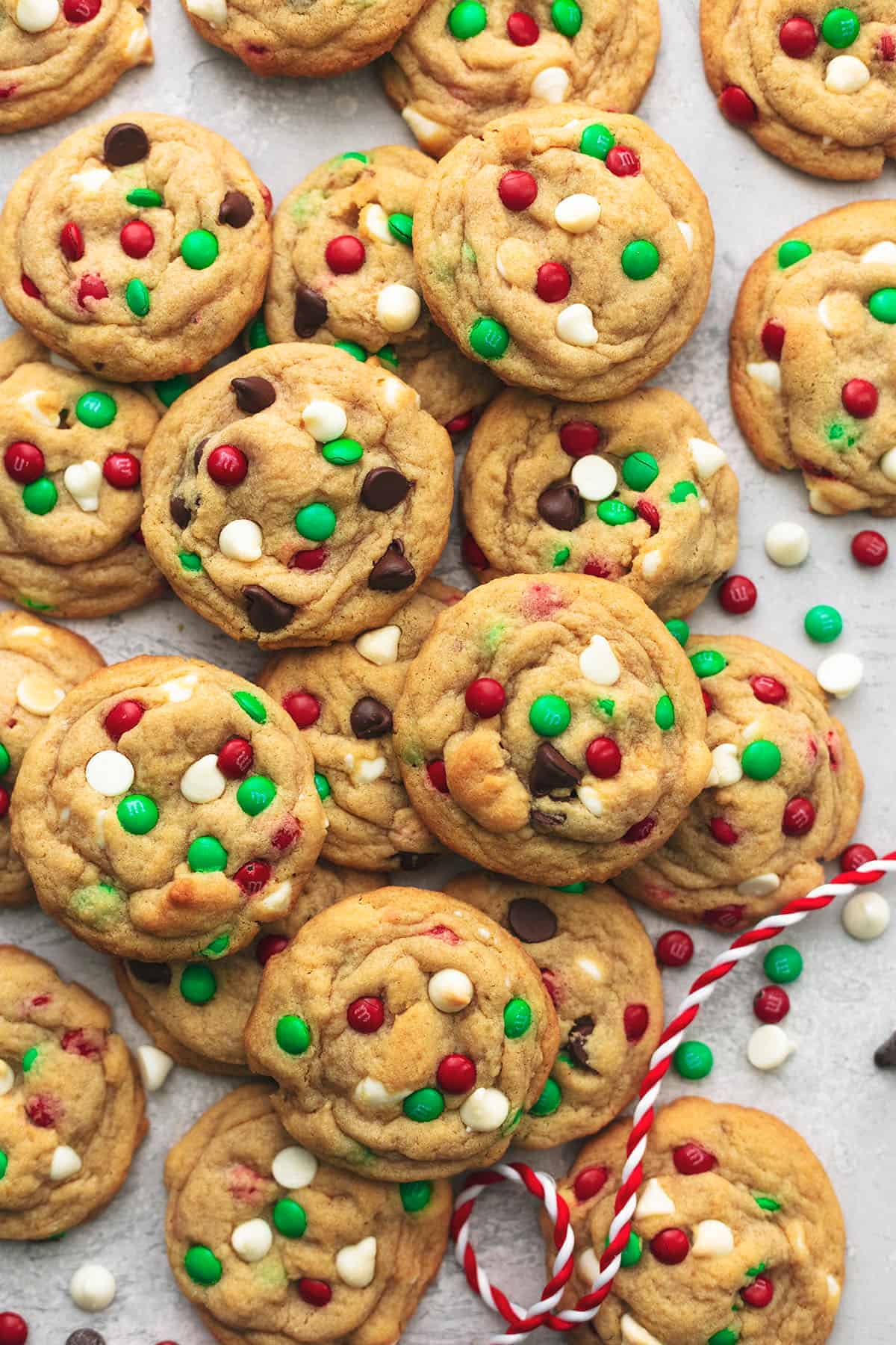 cookies with red and green candies on a parchment lined sheet pan