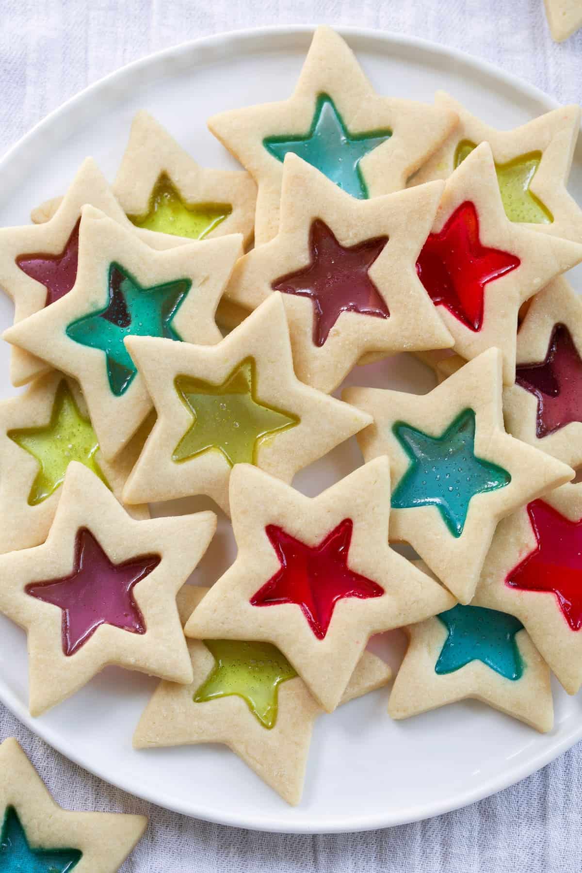 star shaped stained glass cookies on a white plate