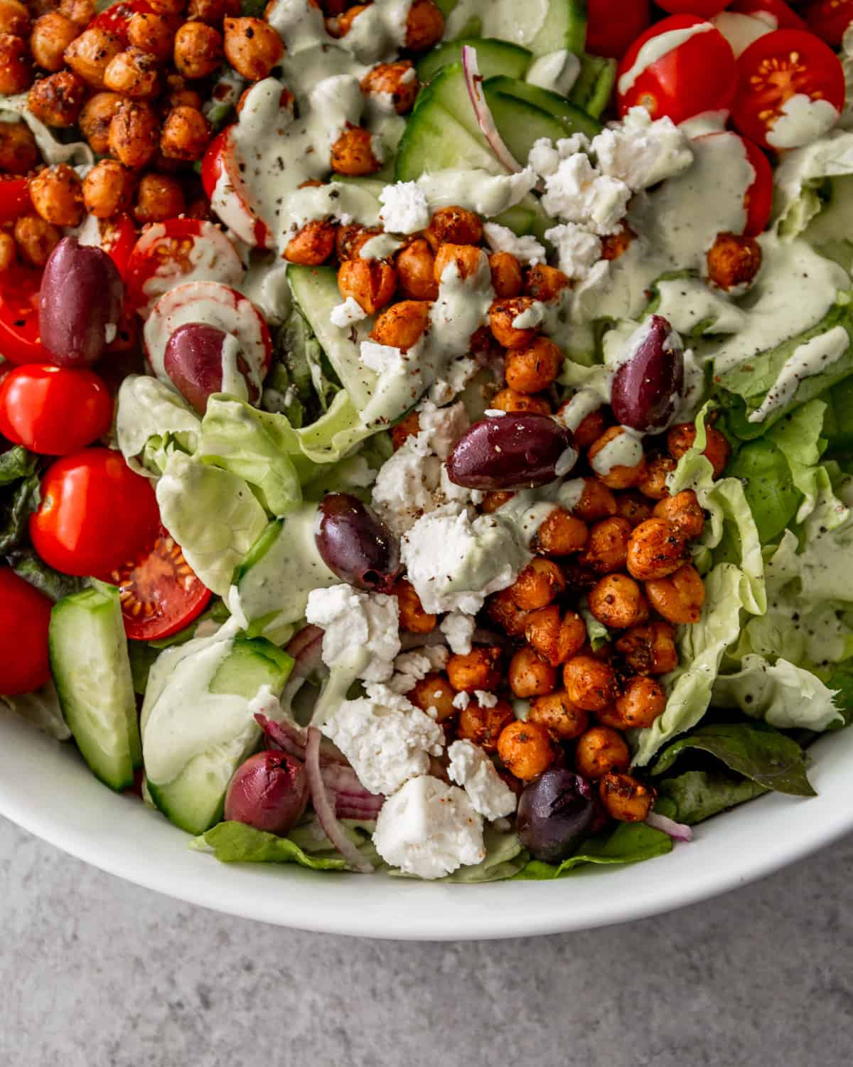 close up image of salad with olives, chickpeas, and dressing