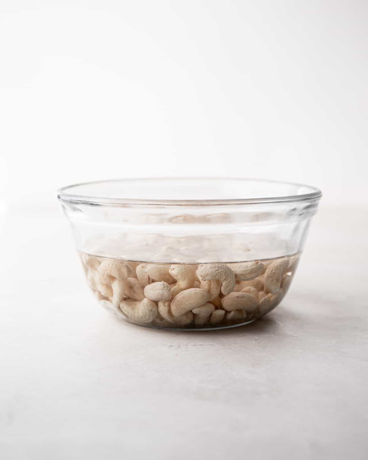 cashews soaking in a clear glass bowl