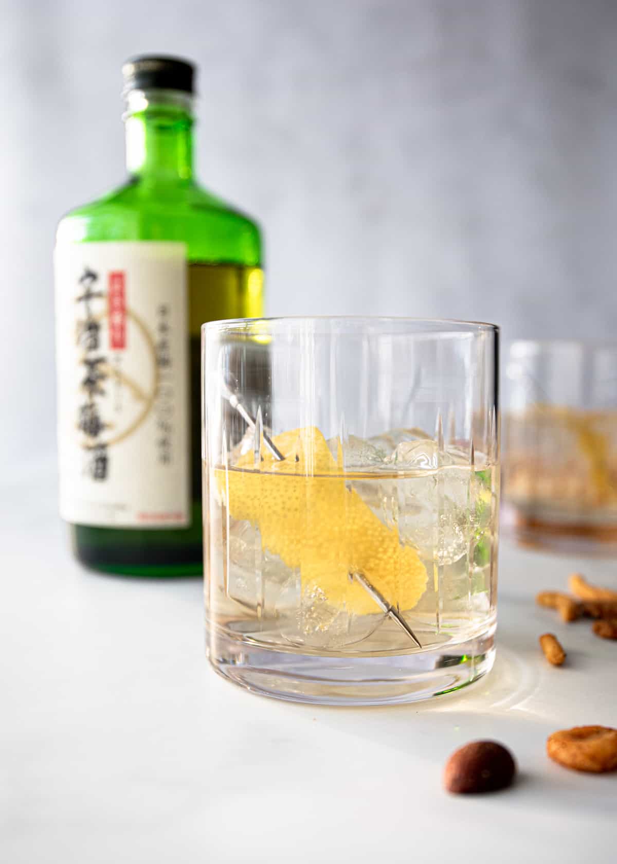 green tea cocktail in a clear glass on a grey countertop