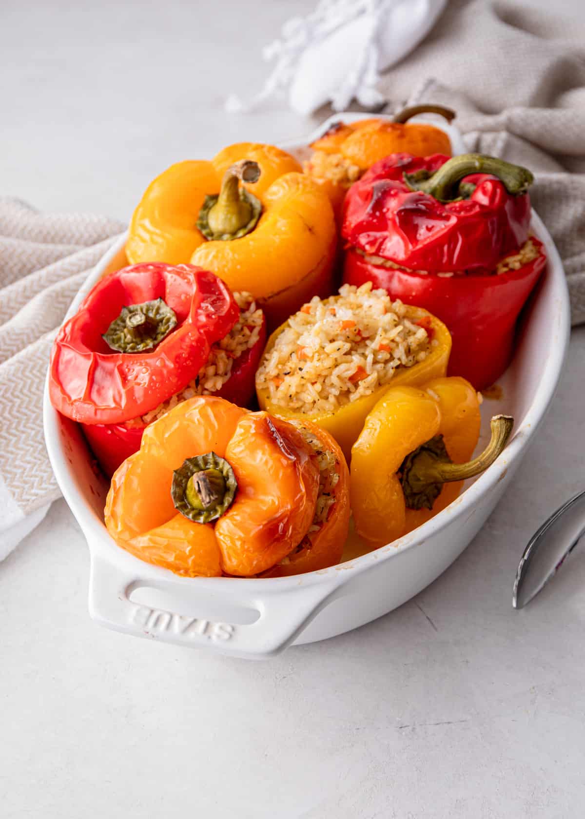 rice stuffed peppers in a white baking dish
