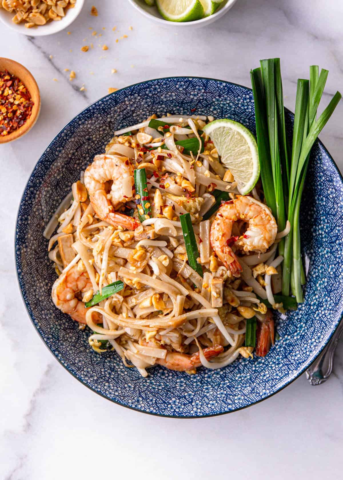 overhead image of pad thai noodles with shrimp and Chinese chives