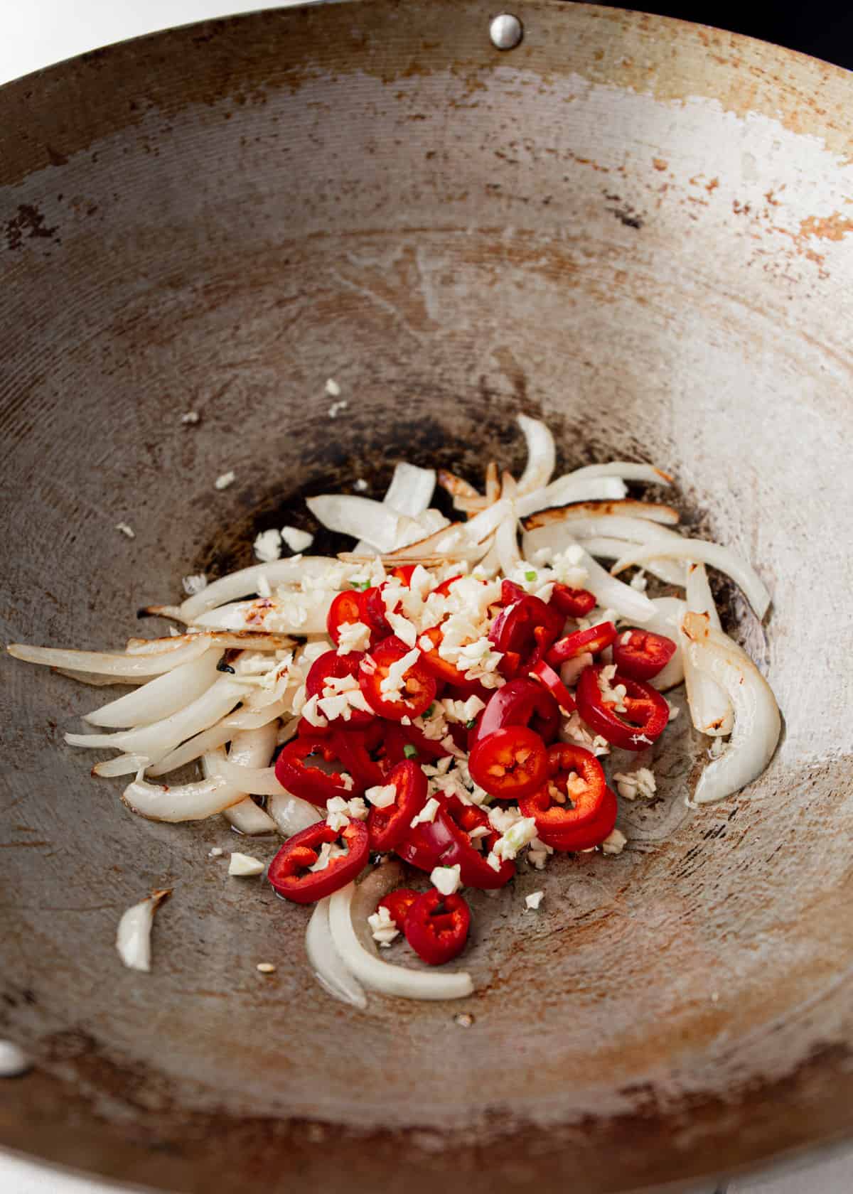 cooking onions, garlic and peppers in a wok