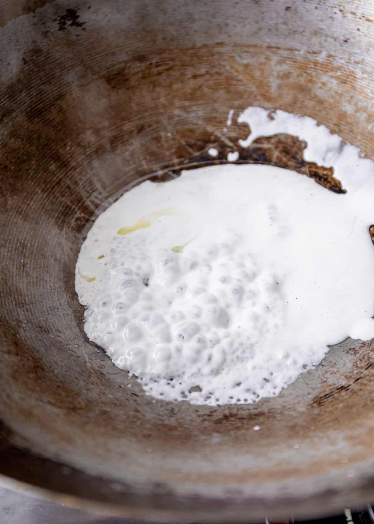 cooking coconut milk in a wok