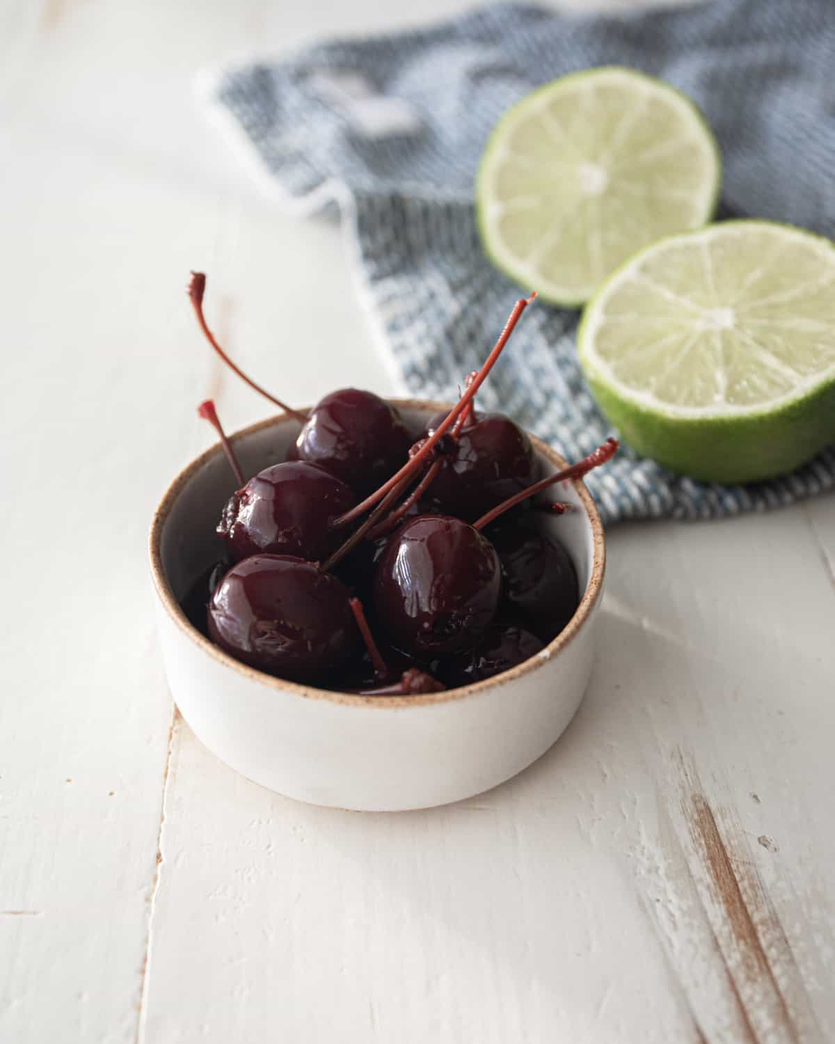 cherries in a white bowl on a grey countertop