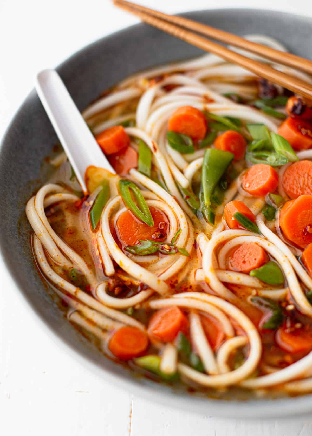 a close up image of miso vegetable soup in a grey bowl