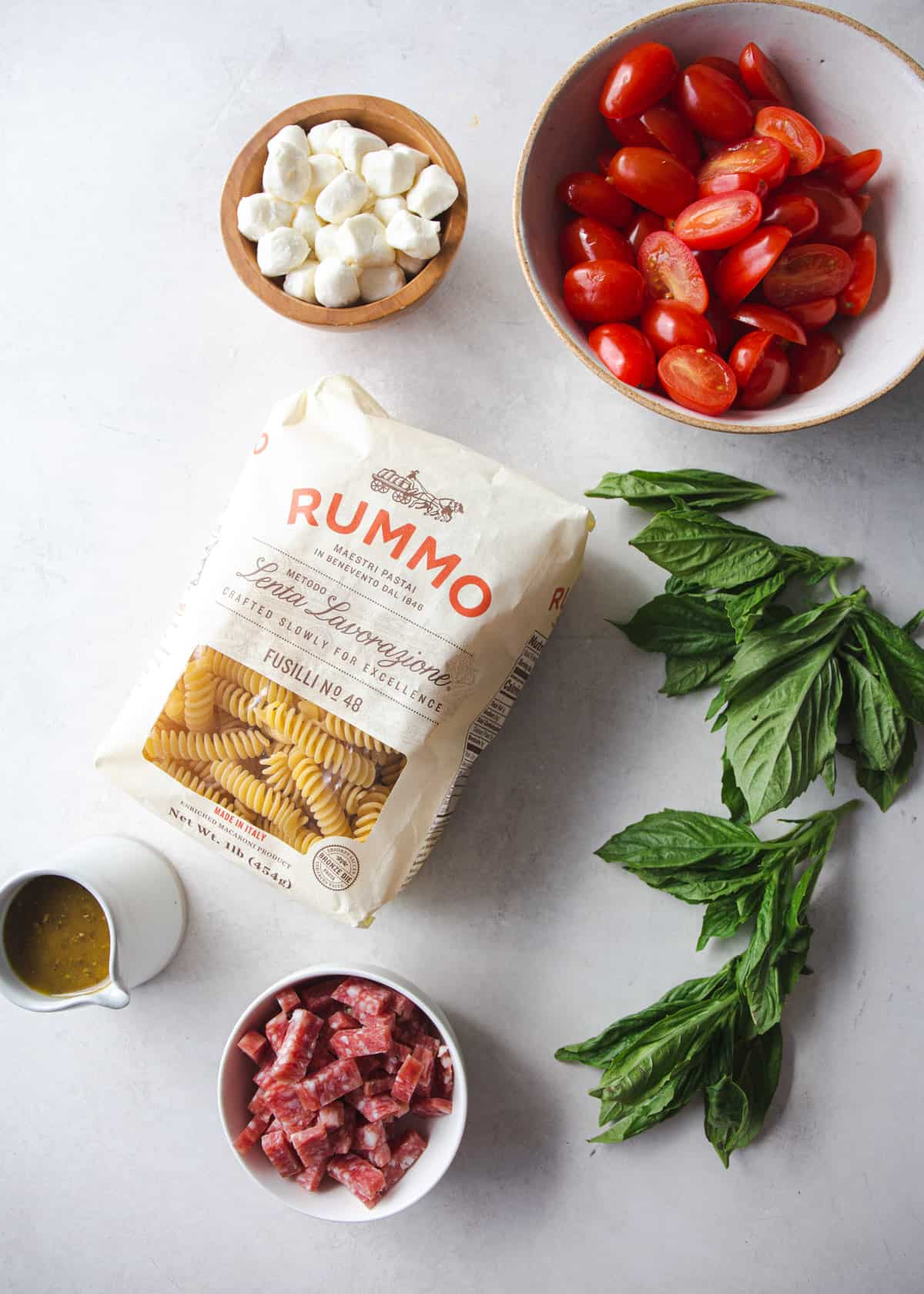 overhead image of ingredients for pasta salad on a grey countertop