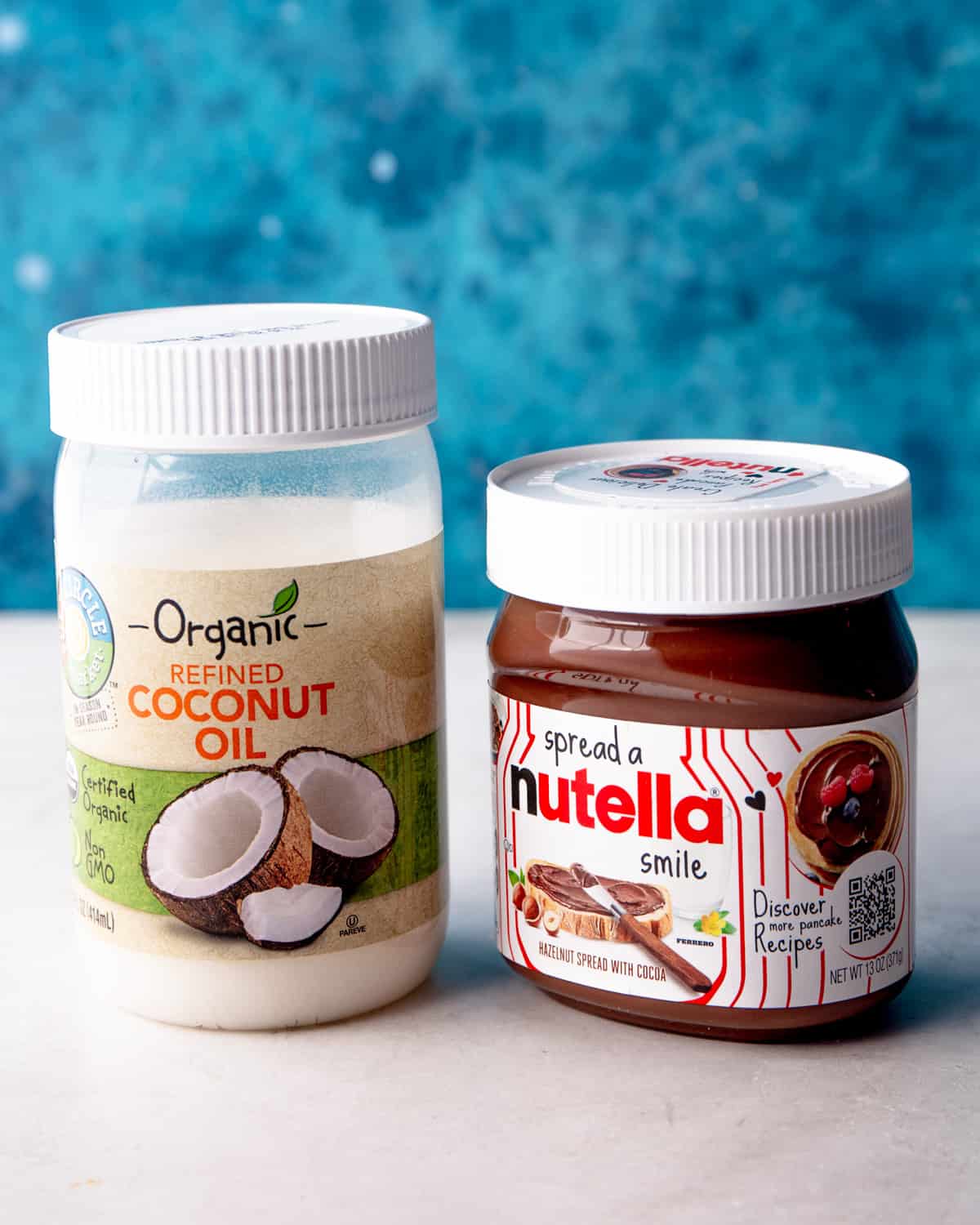 containers of nutella and coconut oil on a grey countertop