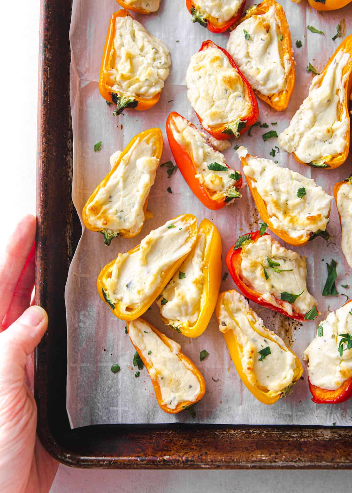 stuffed mini peppers on a parchment lined sheet pan