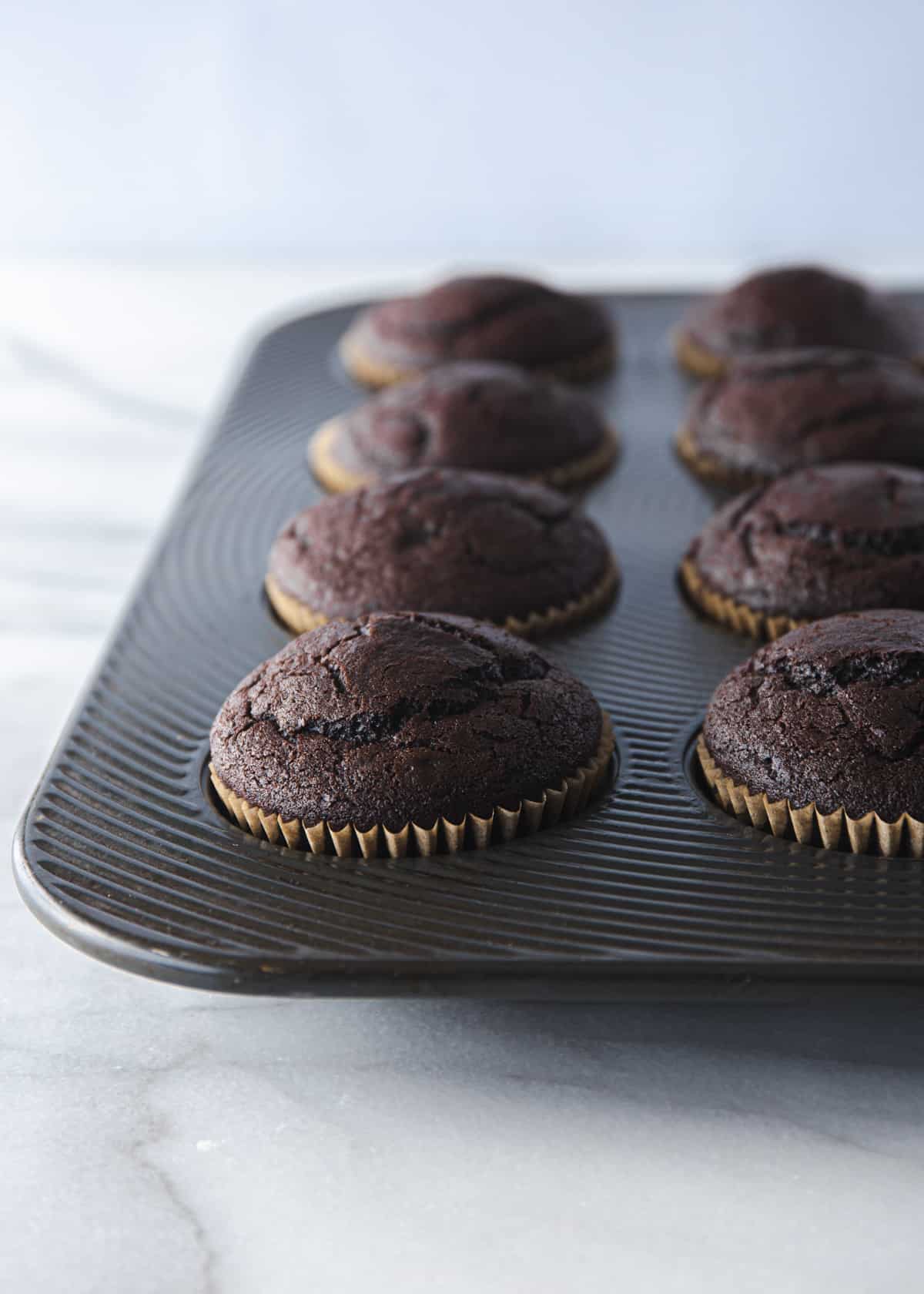 baked chocolate cupcakes in a muffin tin