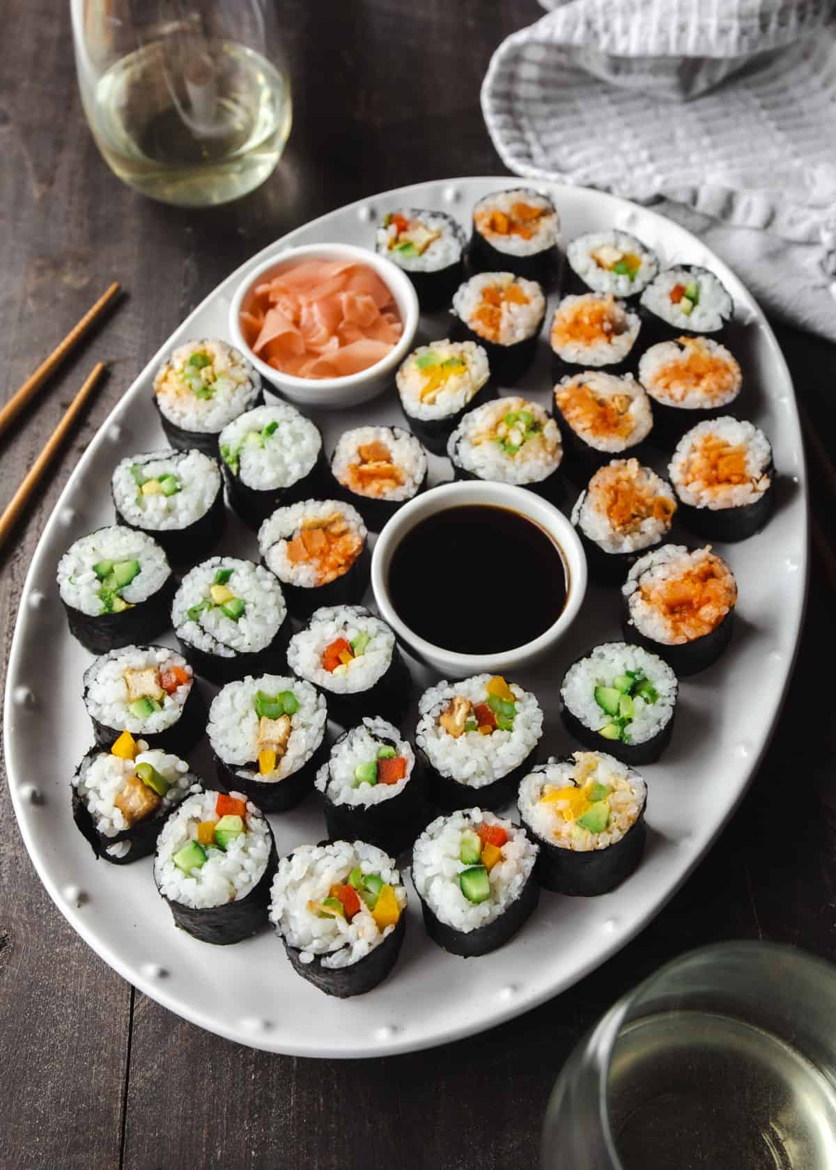 sushi on a white tray with a bowl of soy sauce
