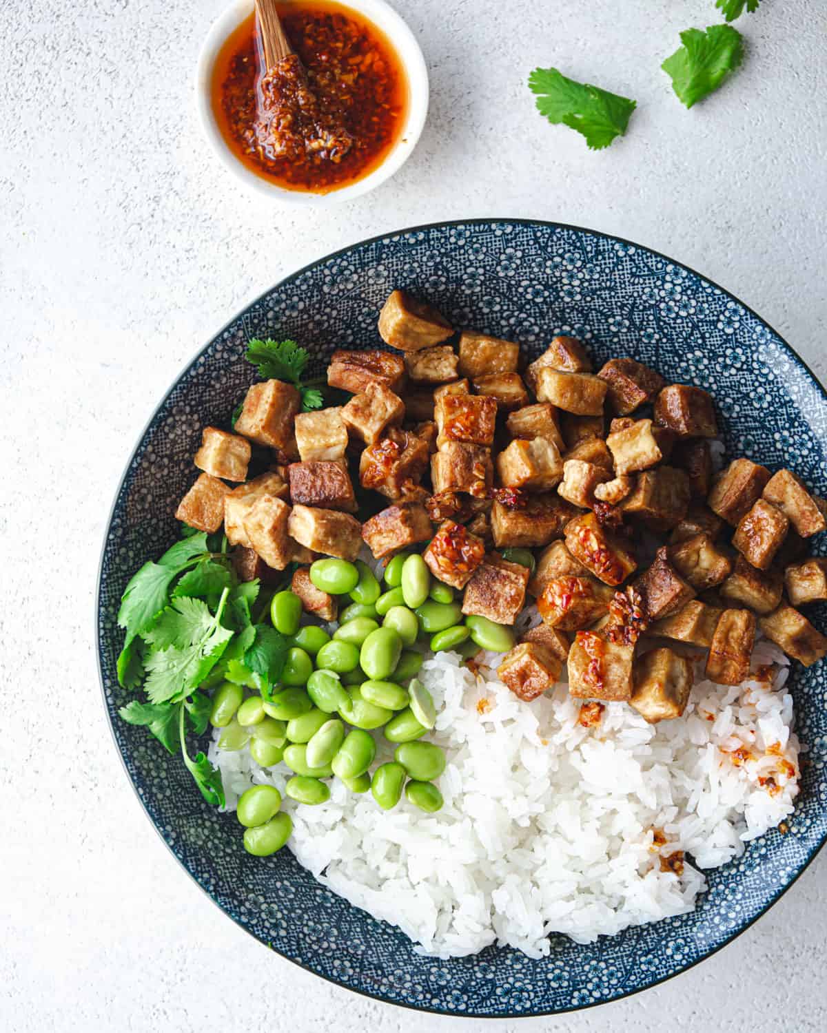 crispy tofu, rice and beans on a blue plate