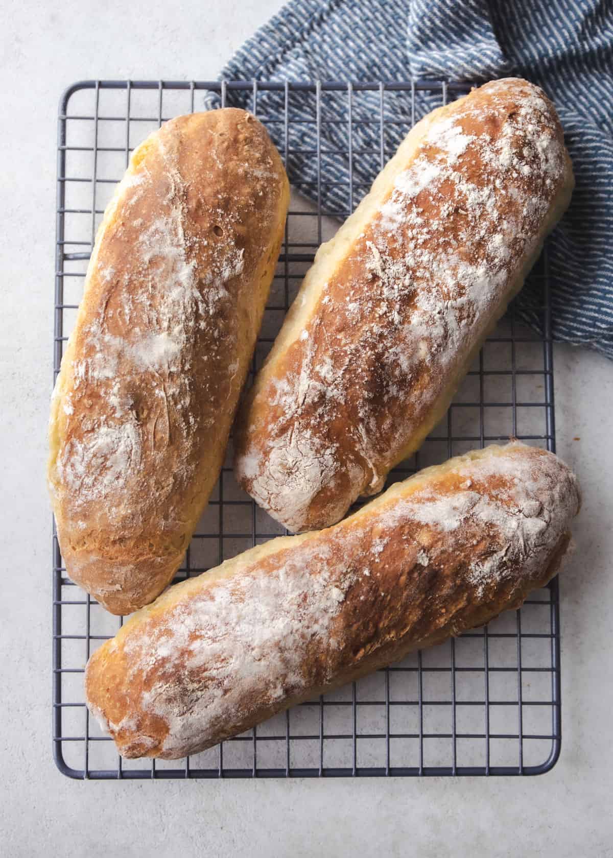 3 loaves of french bread on a cooling rack