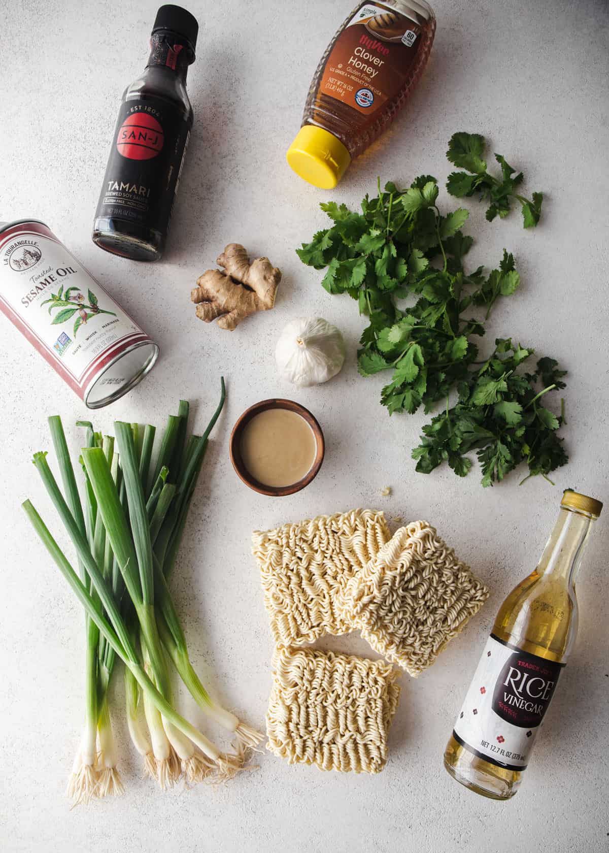 overhead image of ingredients for miso scallion noodles on a grey countertop