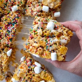 removing a marshmallow cornflake treat from a lined pan