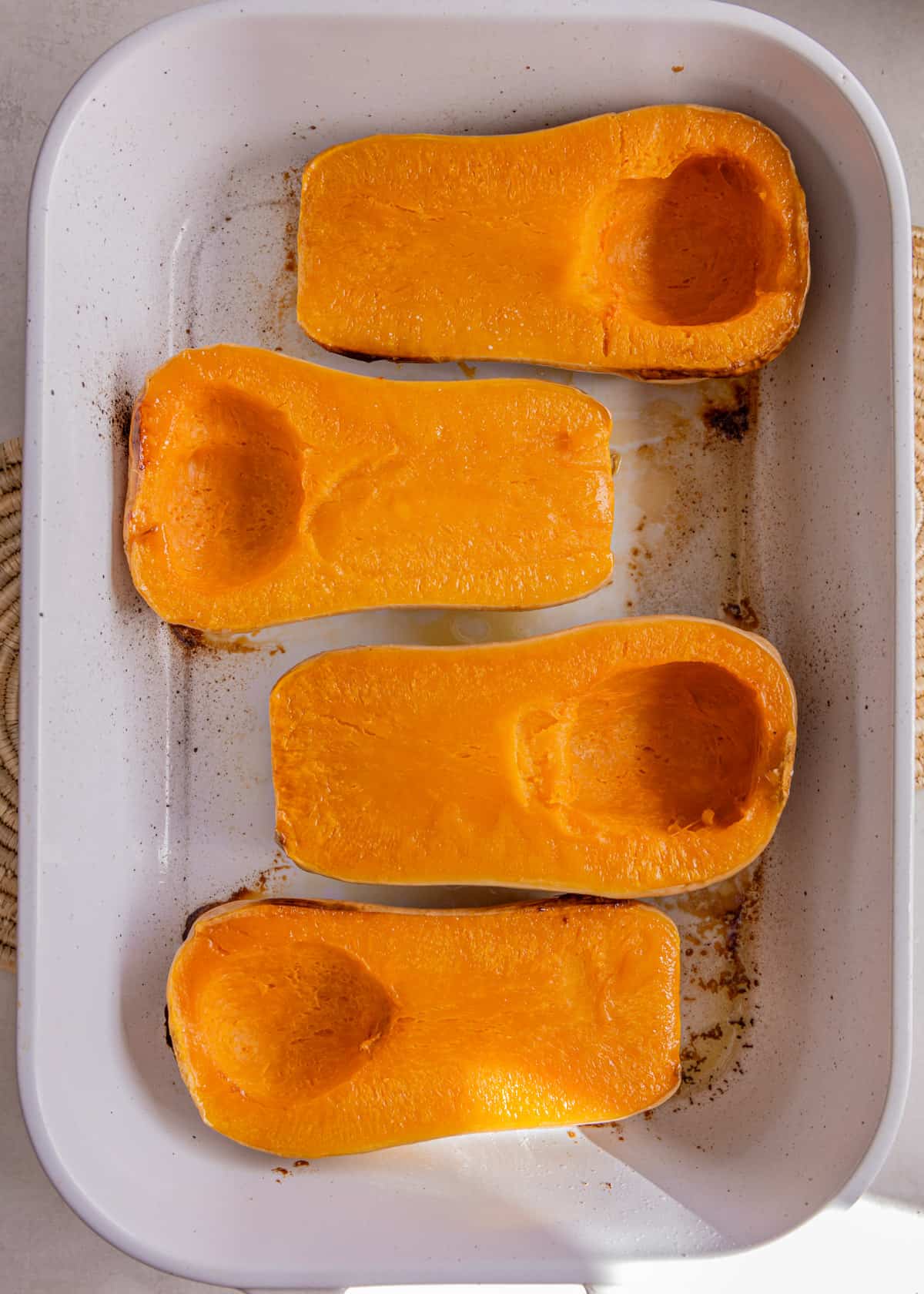 baked squash halves in a white baking dish