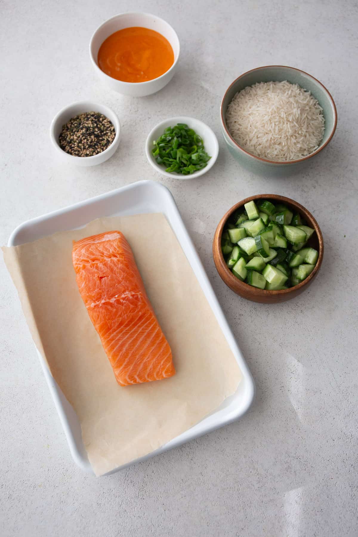 ingredients for salmon sushi bowls on a grey countertop