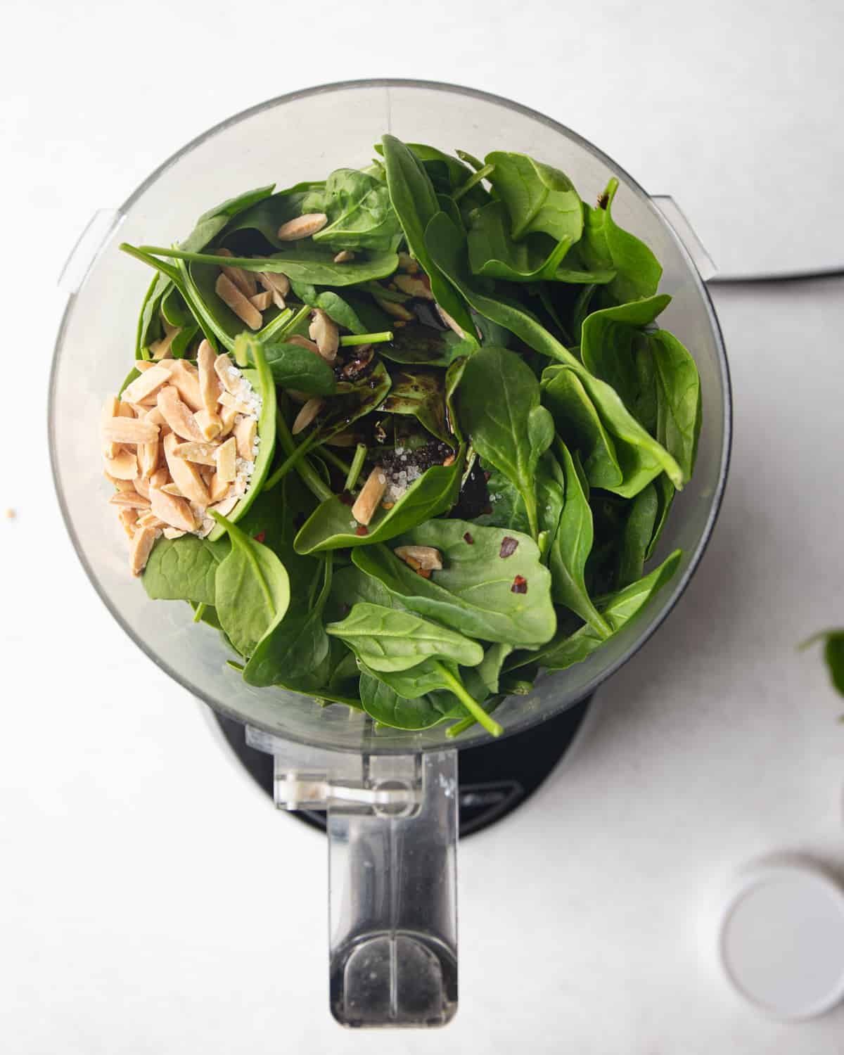 ingredients for spinach pesto in the bowl of a food processor