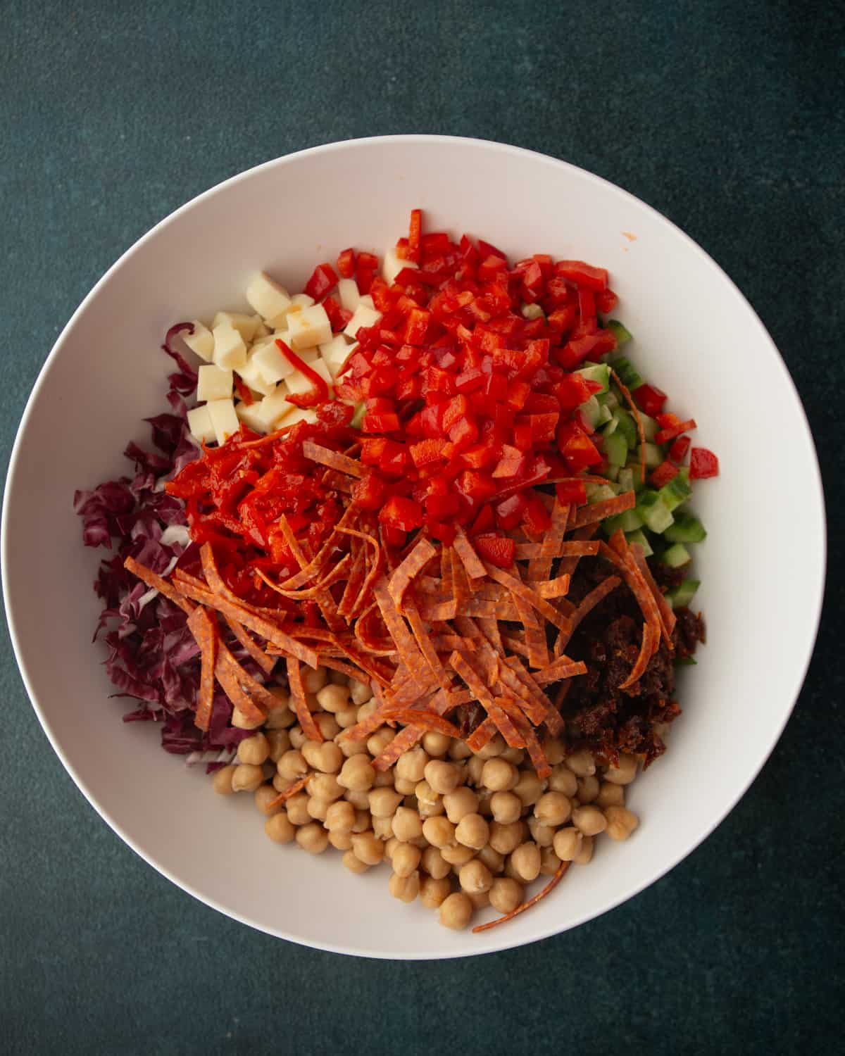 overhead image of salad ingredients in a large white bowl